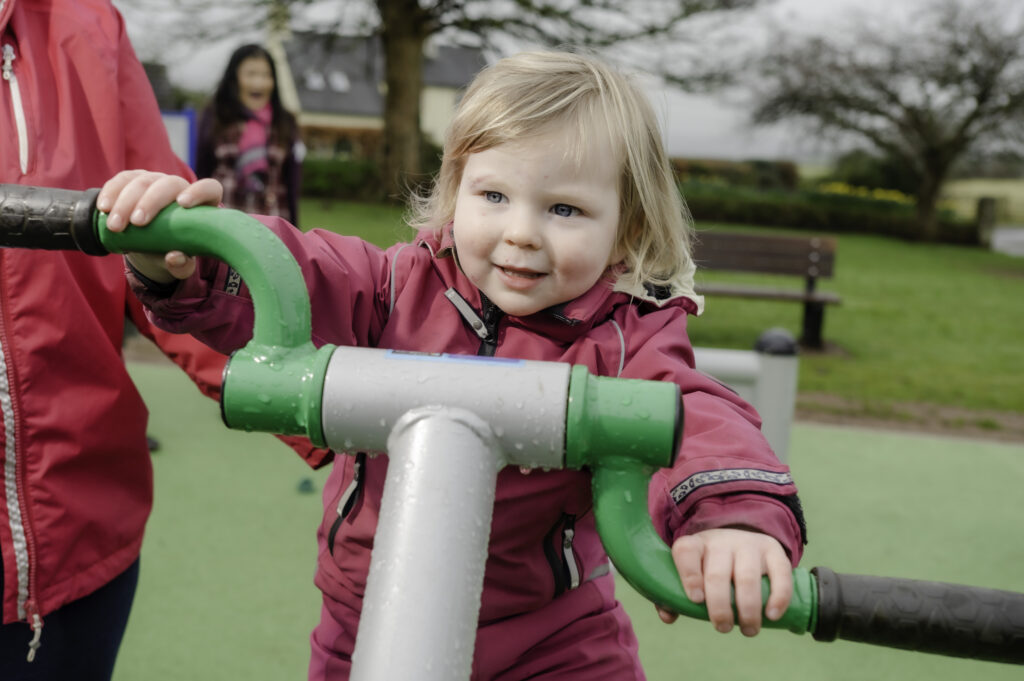 Young girl on outdoor gym equipment