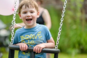 A little boy on a swing in a play park