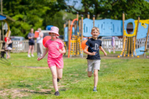 Two children running at a play park