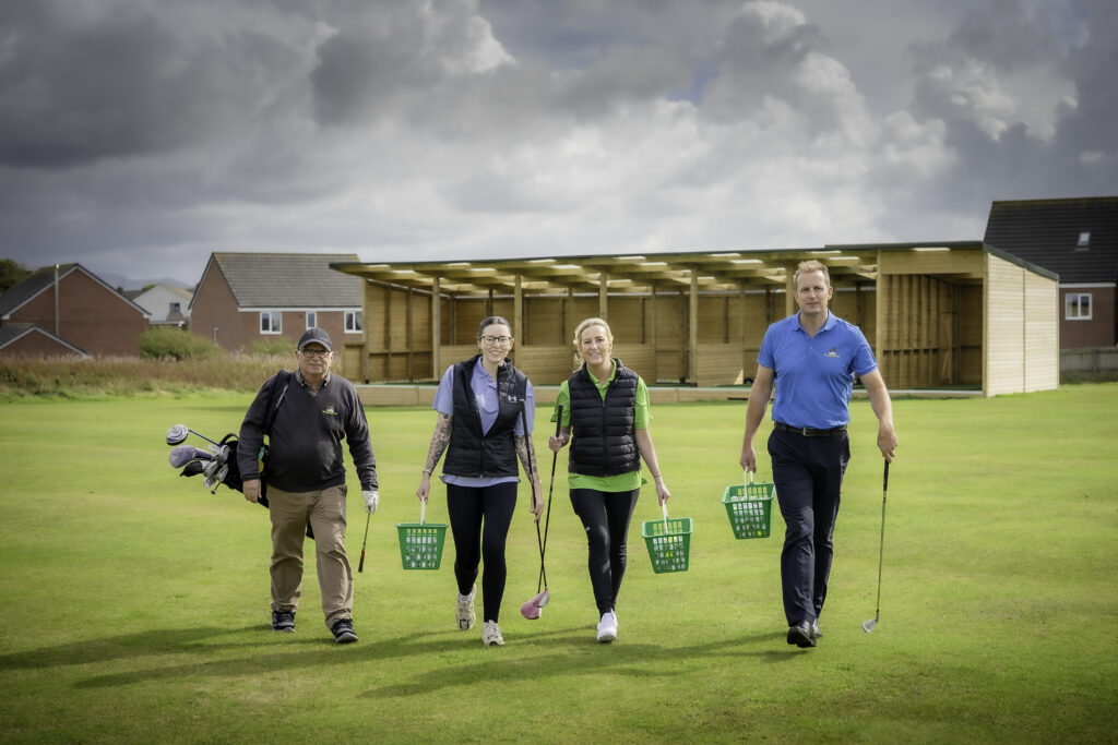 4 golfers on a green with green baskets